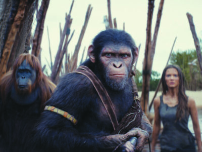 a CGI ape and orangutan and a young woman in a scene from Kingdom of the planet of the apes