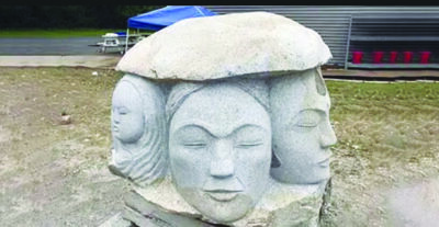 stone sculpture of carved faces looking out