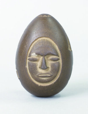 egg shaped stone with what looks like is a human face on it