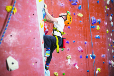 Determined boy practicing rock climbing