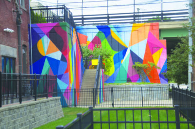 stairway from lower street to overpass, walls painted with colorful geometric blocks