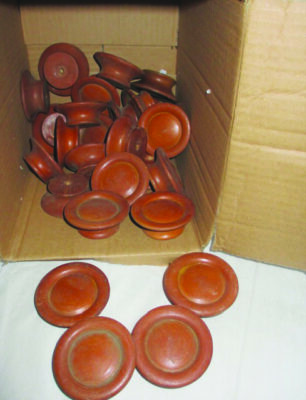 round wooden knobs for drawers piled in cardboard box which is turned on it's side. some knobs falling out