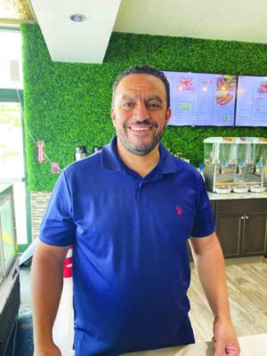 headshot of man with short dark hair and beard standing in restaurant