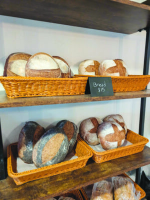 baskets of round artisanal bread loaves sitting on shelves