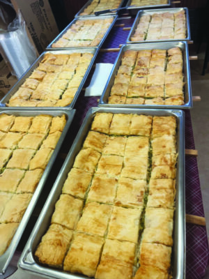 2 rows of trays of spanakopita cut into squares