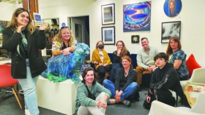 group of people sitting on armchairs in room with art on the walls