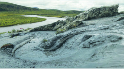 muddy bank of river falling into water