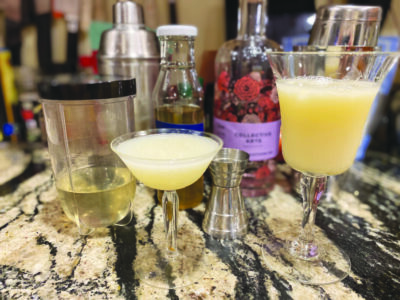 2 stemmed cocktail glasses on counter beside ingredients