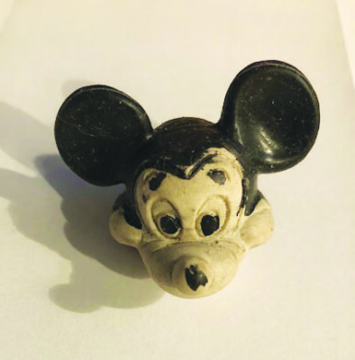 rubber eraser shaped as mickey mouse head with black ears and scull, white cheeks and snout, slightly worn looking