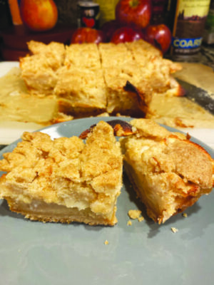 plate with two square pieces of apple bar made of cooked apples on pastry back, with crumble topping