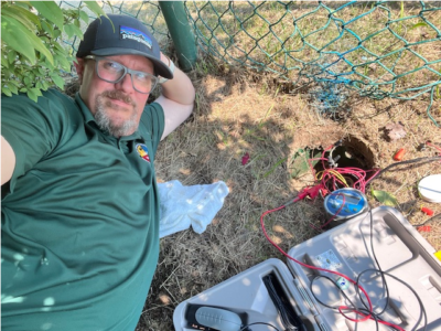 man laying on his side on dead grass beside open tool box