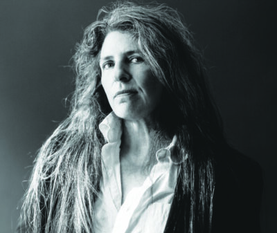 black and white photo of woman with long hair, posing with head slightly raised, serious expression