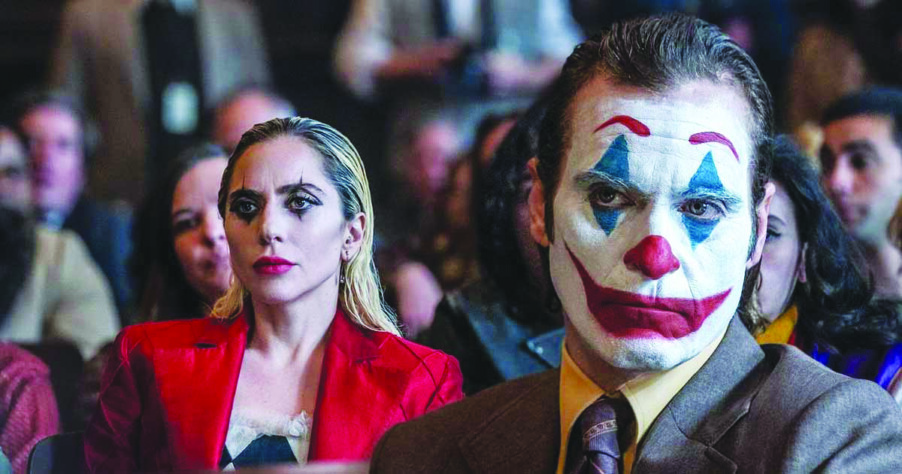 screenshot from Joker: Folie a Deux showing Joaquin Pheonix and Lady Gage in courtroom as Joker and Harley QuinN