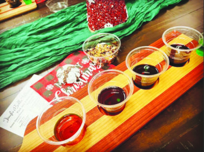 flight of wine in plastic cups on table beside christmas card