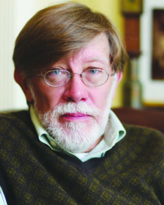 head shot of older man with full beard, wearing glasses and sweater.