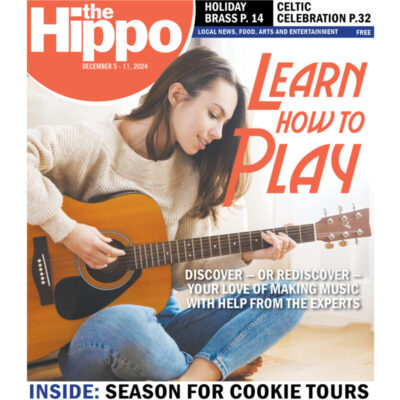 woman playing guitar on front page of hippo newspaper with logo and title learn how to play