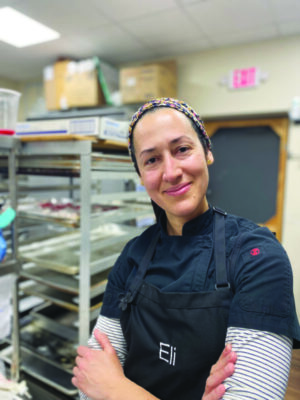 A photo of Elisbet Dupont, smiling and in a black apron.