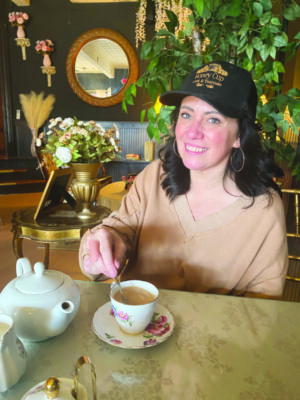 Mara Witt smiling at the camera as she stirs some tea.