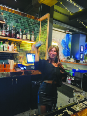 Bartender Jessica True using a cocktail shaker.