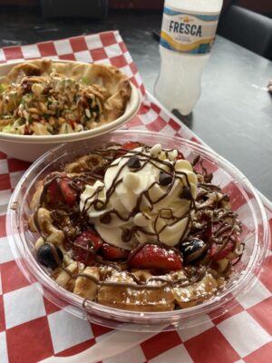 Two bowls of wood sit side by side on a red and white checkered tablecloth