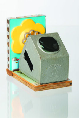 A side viewer made out of wood, metal, a lighter, and a collection of other colorful materials.