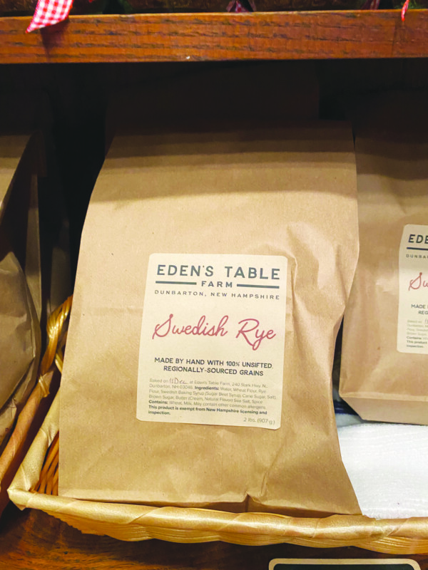 brown paper bag labelled Swedish Rye sitting in backet on shelf with other bagged bread products