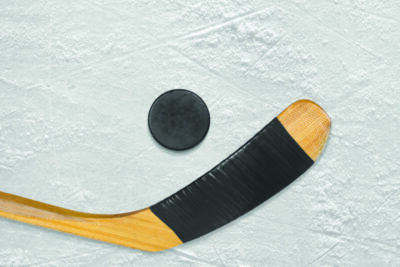 Hockey puck and stick on the ice arena. Texture, background