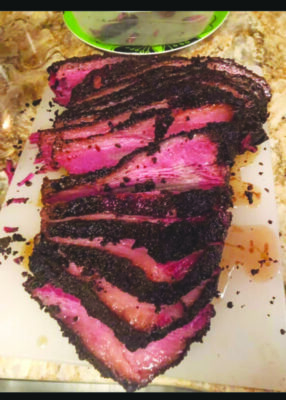 Photo of a corned beef brisket, cut in juicy pink slices.