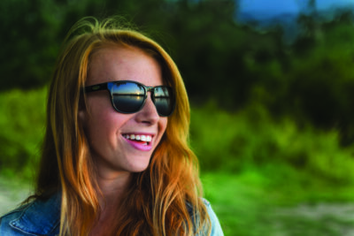 red haired girl / female with sunglasses looking at sunset