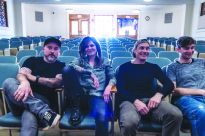 A group shot of the Faith Ann Band in a row of chairs.