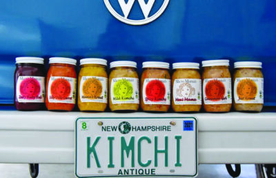 jars of kimchi set on the back of a volkswagon with a license plate reading "kimchi"