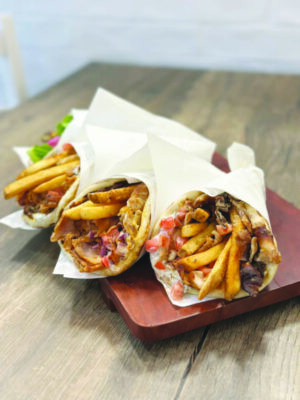 Three delicious-looking gyros well-wrapped stuffed with fries.