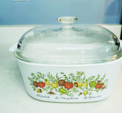 An antique painted pot with a white body and glass lid