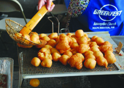 A pile of Loukoumades, a type of fried dough, are dried off.