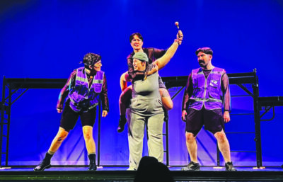 actor dressed in gray as Horton the Elephant holding up a clover, surrounded by 3 actors in purple vests during scene