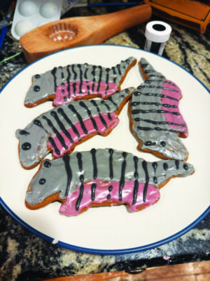 plate on marble counter, holding four cookies shaped and decorated like armadillos