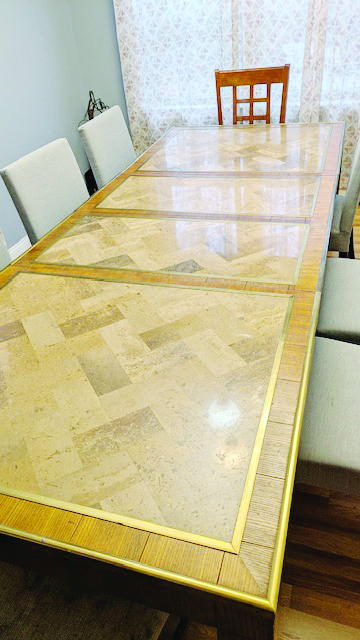 long table with three panels of inlaid marble, with chairs around it