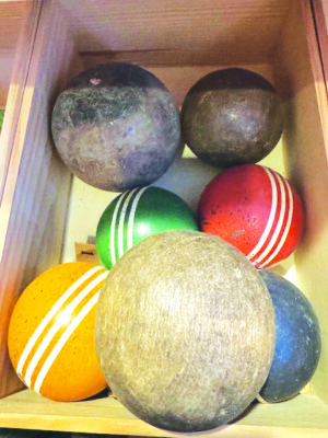 old wooden balls in box, some croquet ball painted colors with white stripes