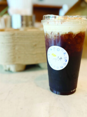 plastic take out cup filled with iced coffee, sitting on a counter