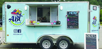 blue food truck with open window, chalkboard menu sitting outside