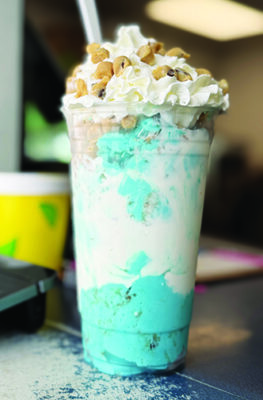 tall milkshake, blue and white ice cream topped with whipped cream and peanut butter chips