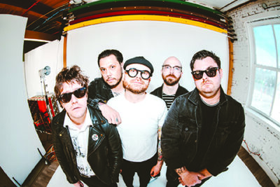 5 male band members in standing in promo shot