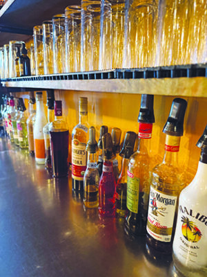 spirits bottles lined up against wall on counter of restaurant