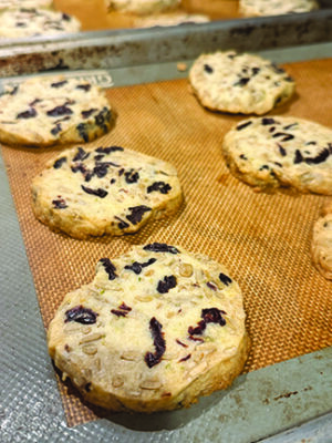round shortbread cookies with dried cherry pieces and light seeds showing on top