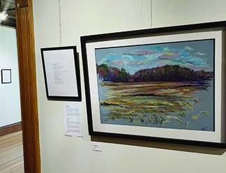 pastel painting of landscape in frame, hanging on wall