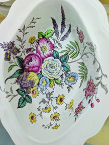 antique white ceramic dish with floral pattern painted in the middle