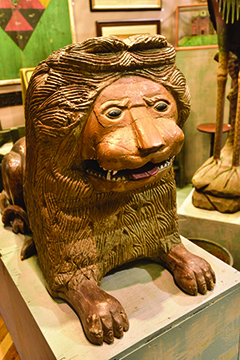 carved wooden lion in resting pose