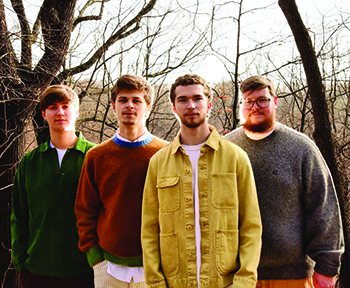 four white men standing in row outside on fall day