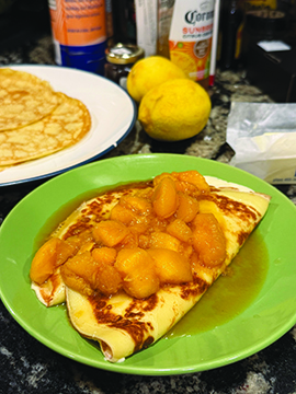 plates with crepes covered in peaches in syrup