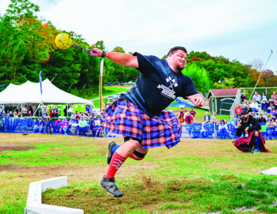 man wearing kilt throwing weight in field games at Scottish festival